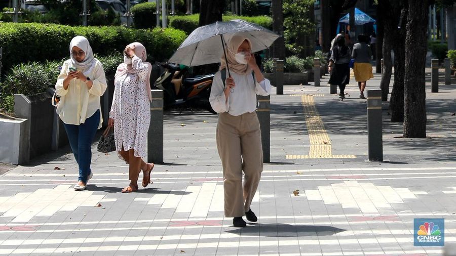 Sejumlah pekerja melintas di jalur pedestrian di kawasan Senayan Sudirman, Jakarta, Jumat (12/5/2023). (վ/Muhammad Sabki)