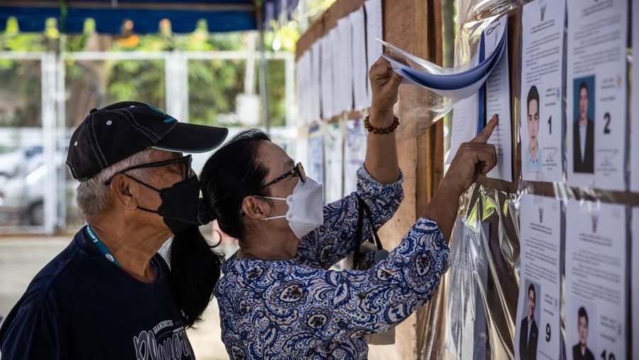 Voters check voting information before casting their ballots in the Khan Na Yao area in Bangkok, Thailand, on Sunday, May 14, 2023. A record number of Thais are projected to go to the ballot boxes in Sunday's parliamentary election as voters decide if they'll shift leadership away from almost a decade of military-backed rule. More than 50 million Thais are eligible to vote, and the Election Commission expects an 80% turnout. Photographer: Andre Malerba/Bloomberg via Getty Images
