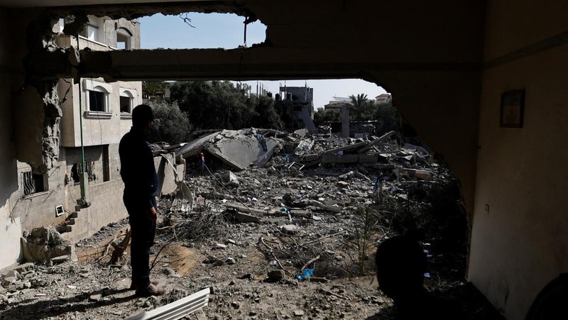 Palestinians stand on the remains of their destroyed houses, which were damaged in an Israeli strike during Israel-Gaza fighting, after a ceasefire was agreed between Palestinian factions and Israel, in Deir Al-Balah, central Gaza Strip May 14, 2023. REUTERS/Ibraheem Abu Mustafa