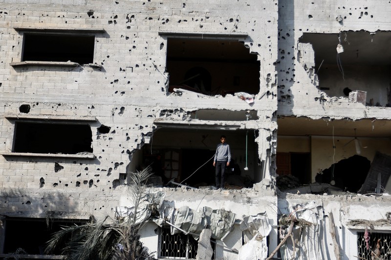 ISRAEL-PALESTINIANS/ Palestinians stand on the remains of their destroyed houses, which were damaged in an Israeli strike during Israel-Gaza fighting, after a ceasefire was agreed between Palestinian factions and Israel, in Deir Al-Balah, central Gaza Strip May 14, 2023. REUTERS/Ibraheem Abu Mustafa
