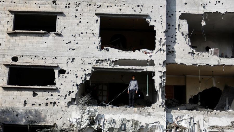 Palestinians stand on the remains of their destroyed houses, which were damaged in an Israeli strike during Israel-Gaza fighting, after a ceasefire was agreed between Palestinian factions and Israel, in Deir Al-Balah, central Gaza Strip May 14, 2023. REUTERS/Ibraheem Abu Mustafa