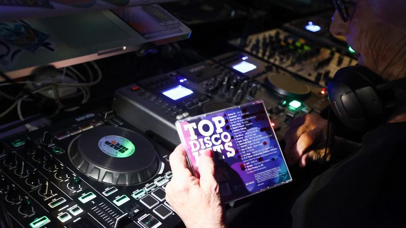Orang-orang menari saat Wirginia Szmyt, DJ berusia 84 tahun, tampil dalam sebuah pesta di Warsawa, Polandia pada 13 Mei 2023. DJ Vika adalah DJ tertua di Polandia dan juga seorang aktivis yang bekerja untuk manula. Sebuah film dokumenter tentang DJ Vika dibuat dan ditayangkan perdana dalam beberapa hari terakhir. (Jakub Porzycki/Anadolu Agency via Getty Images)
