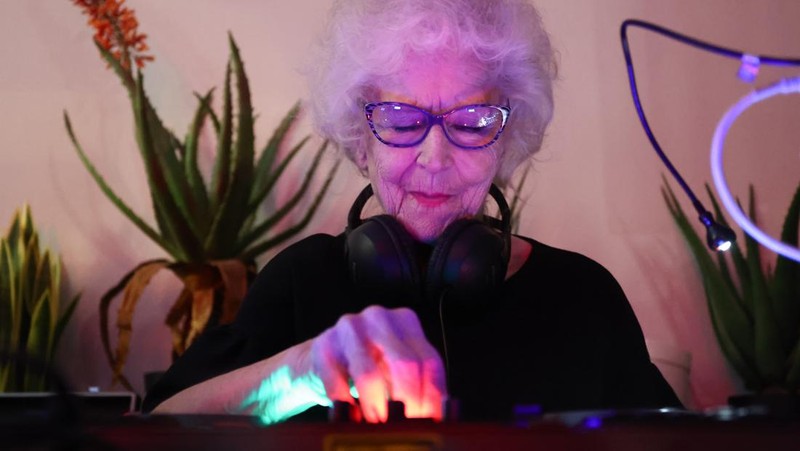 Orang-orang menari saat Wirginia Szmyt, DJ berusia 84 tahun, tampil dalam sebuah pesta di Warsawa, Polandia pada 13 Mei 2023. DJ Vika adalah DJ tertua di Polandia dan juga seorang aktivis yang bekerja untuk manula. Sebuah film dokumenter tentang DJ Vika dibuat dan ditayangkan perdana dalam beberapa hari terakhir. (Jakub Porzycki/Anadolu Agency via Getty Images)