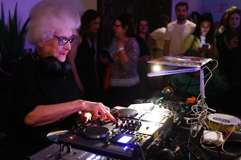 Orang-orang menari saat Wirginia Szmyt, DJ berusia 84 tahun, tampil dalam sebuah pesta di Warsawa, Polandia pada 13 Mei 2023. DJ Vika adalah DJ tertua di Polandia dan juga seorang aktivis yang bekerja untuk manula. Sebuah film dokumenter tentang DJ Vika dibuat dan ditayangkan perdana dalam beberapa hari terakhir. (Jakub Porzycki/Anadolu Agency via Getty Images)