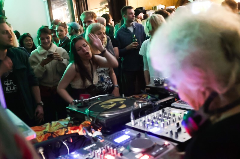 Orang-orang menari saat Wirginia Szmyt, DJ berusia 84 tahun, tampil dalam sebuah pesta di Warsawa, Polandia pada 13 Mei 2023. DJ Vika adalah DJ tertua di Polandia dan juga seorang aktivis yang bekerja untuk manula. Sebuah film dokumenter tentang DJ Vika dibuat dan ditayangkan perdana dalam beberapa hari terakhir. (Jakub Porzycki/Anadolu Agency via Getty Images)