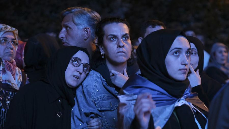 Pendukung Presiden Recep Tayyip Erdogan dan Partai AK (AK Party) menyaksikan hasil pemilu di layar lebar di depan markas AKP pada 14 Mei 2023 di Istanbul Turki. (Mehmet Kacmaz/Getty Images)