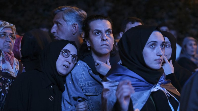 Pendukung Presiden Recep Tayyip Erdogan dan Partai AK (AK Party) menyaksikan hasil pemilu di layar lebar di depan markas AKP pada 14 Mei 2023 di Istanbul Turki. (Mehmet Kacmaz/Getty Images)