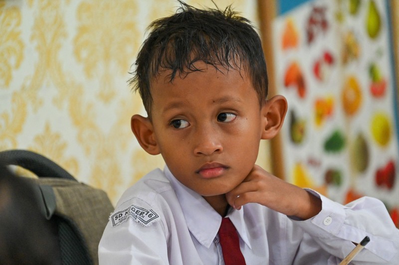 Seorang siswa sekolah dasar menggunakan kipas angin portabel untuk menjaga kesejukan saat cuaca panas di Banda Aceh pada 15 Mei 2023. Seorang siswa sekolah dasar menggunakan kipas angin portabel untuk menjaga kesejukan saat cuaca panas di Banda Aceh pada 15 Mei 2023. (CHAIDEER MAHYUDDIN/AFP via Getty Images)