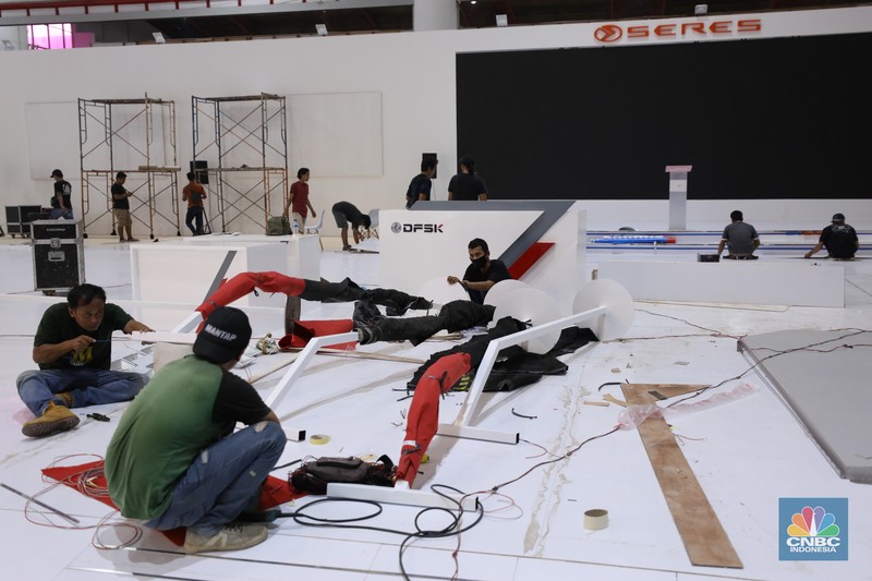 Pekerja menyelesaikan dekorasi pameran kendaraan listrik Periklindo Electric Vehicle Show (PEVS) 2023 di Jakarta, Selasa (16/5/2023). Pameran ini berlangsung pada 17-21 Mei 2023 di JIExpo Kemayoran, Jakarta.