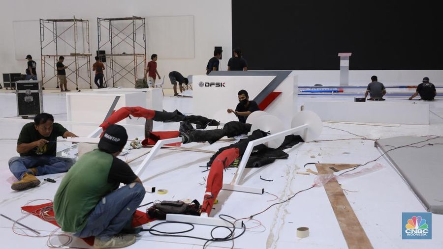 Pekerja menyelesaikan dekorasi pameran kendaraan listrik Periklindo Electric Vehicle Show (PEVS) 2023 di Jakarta, Selasa (16/5/2023). Pameran ini berlangsung pada 17-21 Mei 2023 di JIExpo Kemayoran, Jakarta.