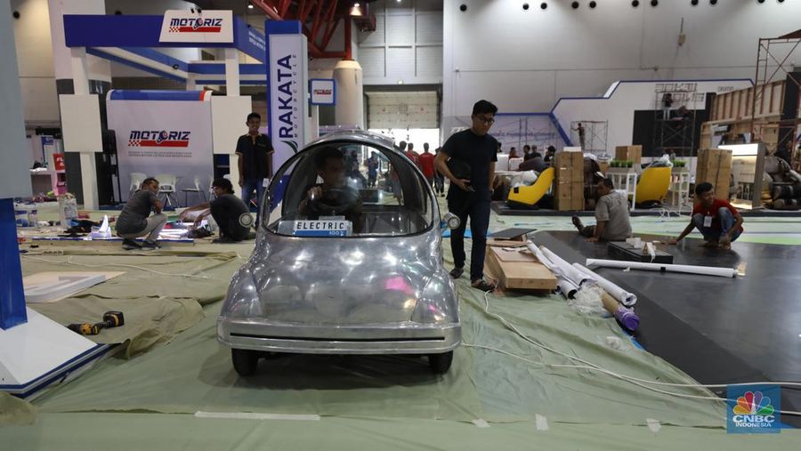 Pekerja menyelesaikan dekorasi pameran kendaraan listrik Periklindo Electric Vehicle Show (PEVS) 2023 di Jakarta, Selasa (16/5/2023). Pameran ini berlangsung pada 17-21 Mei 2023 di JIExpo Kemayoran, Jakarta.