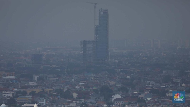 Sejumlah karyawan melihat gedung bertingkat yang tertutup oleh kabut polusi di Jakarta, Senin, (14/8). (CNBC Indonesia/Muhammad Sabki)