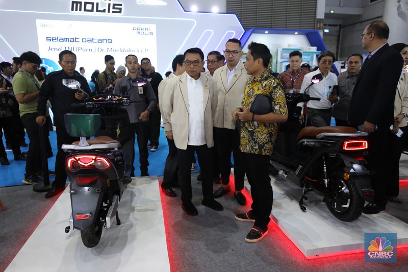 Ketua Perkumpulan Industri Kendaraan Listrik Indonesia (Periklindo), Moeldoko (tengah) mengunjungi booth pameran PERIKLINDO Electric Vehicle Show (PEVS) 2023 di Jakarta, Rabu (17/5/2023).  Pameran ini menjadi medium untuk mengajak masyarakat Indonesia mendukung kebijakan pemerintah dalam mencapai target net zero emission di tahun 2060. (CNBC Indonesia/Tri Susilo)