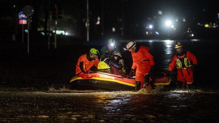 Petugas pemadam kebakaran dan penyelamat sipil mengevakuasi penduduk dengan perahu karet di Forli pada 17 Mei 2023 setelah hujan lebat menyebabkan banjir besar di Italia tengah, di mana kereta dihentikan dan sekolah ditutup di banyak kota sementara orang diminta meninggalkan lantai dasar rumah mereka dan untuk menghindari pergi keluar. (-/AFP via Getty Images)