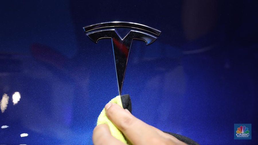 Seorang pegawai membersihkan mobil listrik Tesla yang dipajang dalam pameran Periklindo Electric Vehicle Show (PEVS) di Ji Expo Kemayoran pada (17/5/2023). (CNBC Indonesia/Tri Susilo)