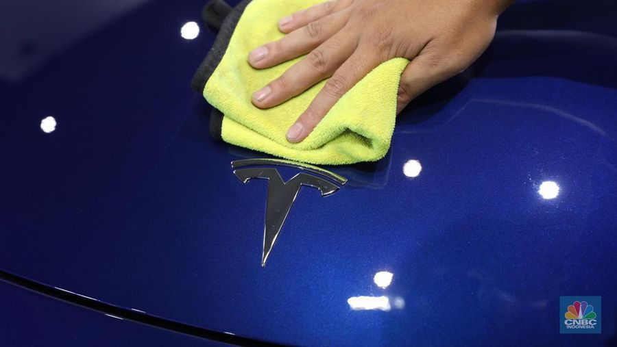 Seorang pegawai membersihkan mobil listrik Tesla yang dipajang dalam pameran Periklindo Electric Vehicle Show (PEVS) di Ji Expo Kemayoran pada (17/5/2023). (CNBC Indonesia/Tri Susilo)