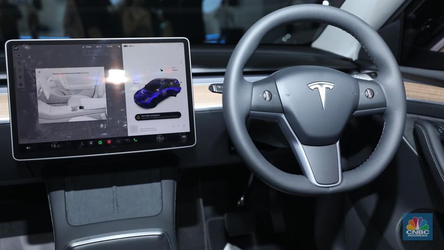 Seorang pegawai membersihkan mobil listrik Tesla yang dipajang dalam pameran Periklindo Electric Vehicle Show (PEVS) di Ji Expo Kemayoran pada (17/5/2023). (CNBC Indonesia/Tri Susilo)