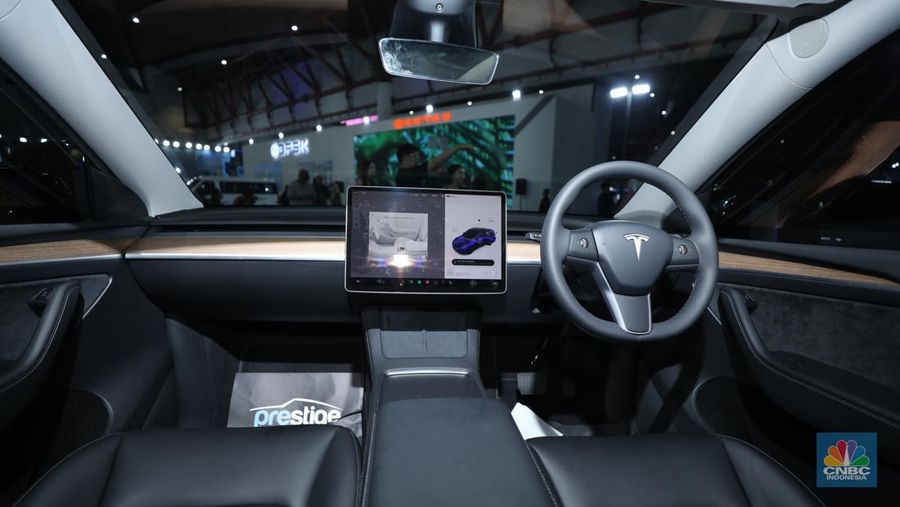 Seorang pegawai membersihkan mobil listrik Tesla yang dipajang dalam pameran Periklindo Electric Vehicle Show (PEVS) di Ji Expo Kemayoran pada (17/5/2023). (CNBC Indonesia/Tri Susilo)