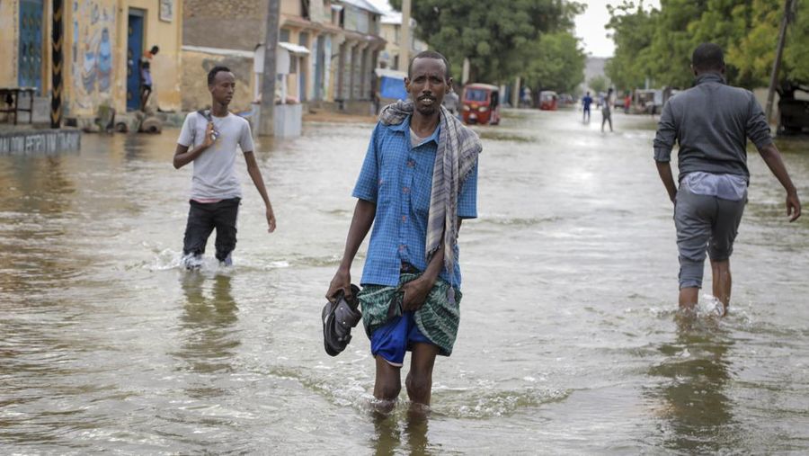 Seorang pria berjalan melewati banjir di sebuah jalan di kota Beledweyne, di Somalia, Senin, 15 Mei 2023. Perkiraan dari Kantor PBB untuk Koordinasi Urusan Kemanusiaan adalah bahwa 460.000 orang telah terkena dampak banjir akibat hujan lebat sejak pertengahan Berbaris. (AP Photo)