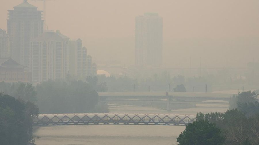 Buildings shrouded in smoke from wildfires in Calgary, Alberta, Canada, on Wednesday, May 17, 2023. Scenes in Calgary were reminiscent of Seattle last summer and San Francisco in 2020 as wind currents blew smothering wildfire smoke into those population centers, compromising air quality. Photographer: Todd Korol/Bloomberg via Getty Images