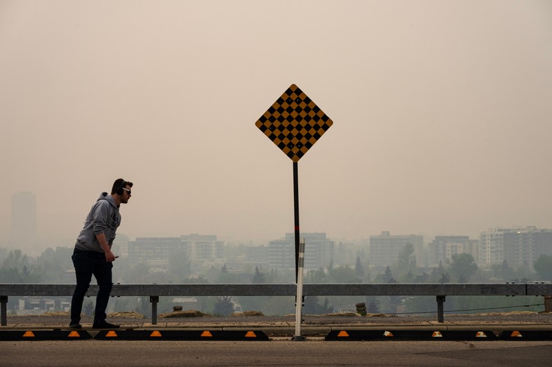 Buildings shrouded in smoke from wildfires in Calgary, Alberta, Canada, on Wednesday, May 17, 2023. Scenes in Calgary were reminiscent of Seattle last summer and San Francisco in 2020 as wind currents blew smothering wildfire smoke into those population centers, compromising air quality. Photographer: Todd Korol/Bloomberg via Getty Images