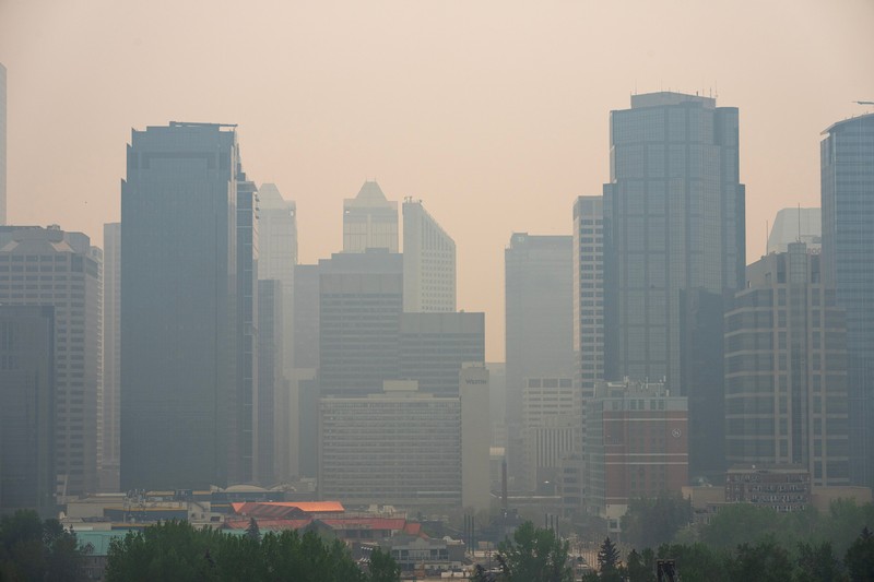 Buildings shrouded in smoke from wildfires in Calgary, Alberta, Canada, on Wednesday, May 17, 2023. Scenes in Calgary were reminiscent of Seattle last summer and San Francisco in 2020 as wind currents blew smothering wildfire smoke into those population centers, compromising air quality. Photographer: Todd Korol/Bloomberg via Getty Images