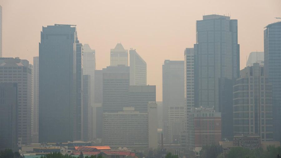 Buildings shrouded in smoke from wildfires in Calgary, Alberta, Canada, on Wednesday, May 17, 2023. Scenes in Calgary were reminiscent of Seattle last summer and San Francisco in 2020 as wind currents blew smothering wildfire smoke into those population centers, compromising air quality. Photographer: Todd Korol/Bloomberg via Getty Images