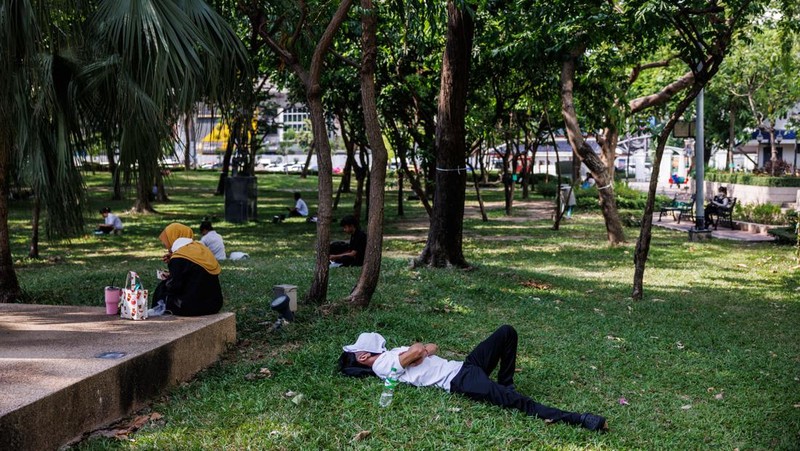 A man sleeps at a park in Bangkok, Thailand, on Thursday, May 18, 2023. The emerging El Nino is already contributing to severe heat that's roasted Southeast Asia in recent weeks. The weather pattern typically results in hotter, drier conditions in many parts of Asia. Photographer: Andre Malerba/Bloomberg via Getty Images