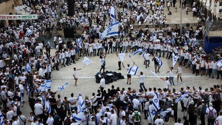 Israelis wave national flags as they gather at the Western Wall in the Old City of Jerusalem during the Israeli 'flags march' to mark 