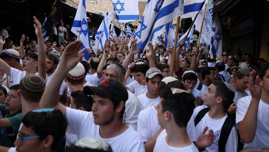 Yahudi Ultranasionalis Israel memegang bendera Israel saat mereka berbaris di kawasan Muslim kota tua Yerusalem pada 18 Mei 2023 di Yerusalem, Israel. Otoritas Israel akan mengizinkan orang-orang Yahudi Ortodoks berparade melalui Muslim Quarter Yerusalem dalam sebuah keputusan yang mengancam akan memicu kembali kekerasan di kota suci tersebut. (Amir Levy/Getty Images)
