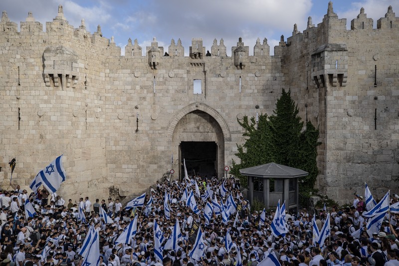 Yahudi Ultranasionalis Israel memegang bendera Israel saat mereka berbaris di kawasan Muslim kota tua Yerusalem pada 18 Mei 2023 di Yerusalem, Israel. Yahudi Ultranasionalis Israel memegang bendera Israel saat mereka berbaris di kawasan Muslim kota tua Yerusalem pada 18 Mei 2023 di Yerusalem, Israel. Otoritas Israel akan mengizinkan orang-orang Yahudi Ortodoks berparade melalui Muslim Quarter Yerusalem dalam sebuah keputusan yang mengancam akan memicu kembali kekerasan di kota suci tersebut. (Amir Levy/Getty Images)