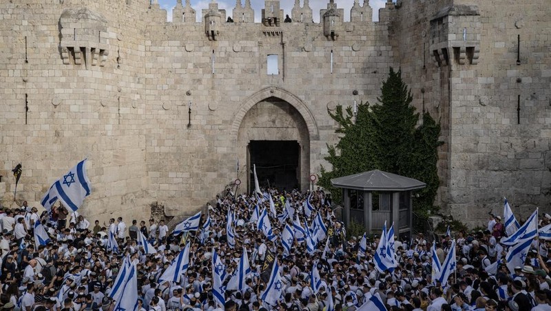 Yahudi Ultranasionalis Israel memegang bendera Israel saat mereka berbaris di kawasan Muslim kota tua Yerusalem pada 18 Mei 2023 di Yerusalem, Israel. Otoritas Israel akan mengizinkan orang-orang Yahudi Ortodoks berparade melalui Muslim Quarter Yerusalem dalam sebuah keputusan yang mengancam akan memicu kembali kekerasan di kota suci tersebut. (Amir Levy/Getty Images)