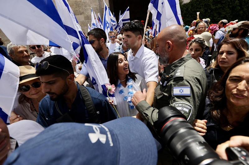 Yahudi Ultranasionalis Israel memegang bendera Israel saat mereka berbaris di kawasan Muslim kota tua Yerusalem pada 18 Mei 2023 di Yerusalem, Israel. Otoritas Israel akan mengizinkan orang-orang Yahudi Ortodoks berparade melalui Muslim Quarter Yerusalem dalam sebuah keputusan yang mengancam akan memicu kembali kekerasan di kota suci tersebut. (Amir Levy/Getty Images)