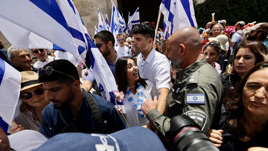 Pemukim Yahudi melakukan pawai bendera di Gerbang Damaskus di Kota Tua di bawah perlindungan polisi Israel di Yerusalem pada 18 Mei 2023. Beberapa warga Palestina yang bereaksi terhadap pawai tersebut ditahan oleh Polisi Israel. (Mostafa Alkharouf/Anadolu Agency via Getty Images)