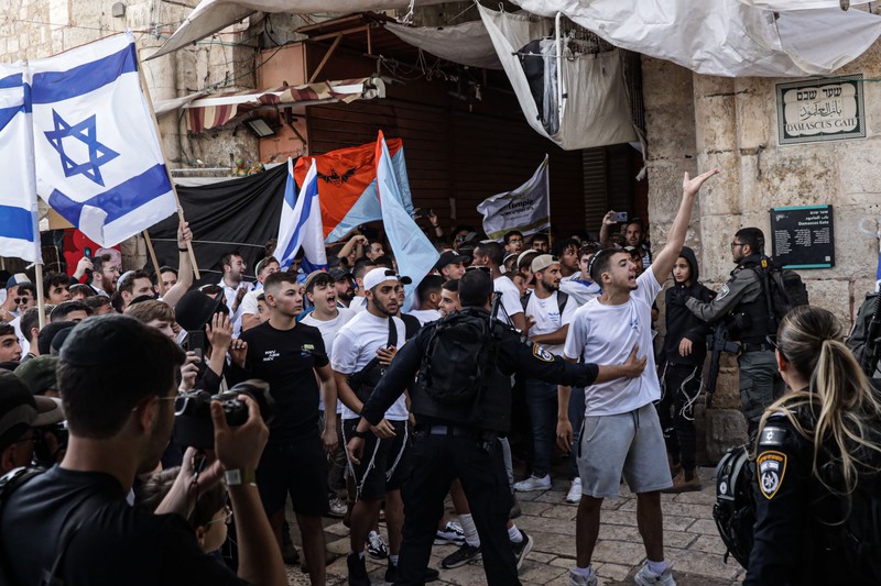 Yahudi Ultranasionalis Israel memegang bendera Israel saat mereka berbaris di kawasan Muslim kota tua Yerusalem pada 18 Mei 2023 di Yerusalem, Israel. Yahudi Ultranasionalis Israel memegang bendera Israel saat mereka berbaris di kawasan Muslim kota tua Yerusalem pada 18 Mei 2023 di Yerusalem, Israel. Otoritas Israel akan mengizinkan orang-orang Yahudi Ortodoks berparade melalui Muslim Quarter Yerusalem dalam sebuah keputusan yang mengancam akan memicu kembali kekerasan di kota suci tersebut. (Amir Levy/Getty Images)