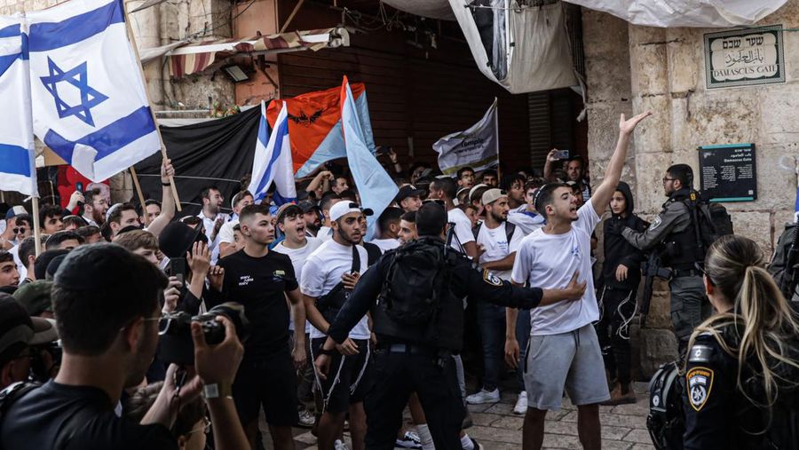 Yahudi Ultranasionalis Israel memegang bendera Israel saat mereka berbaris di kawasan Muslim kota tua Yerusalem pada 18 Mei 2023 di Yerusalem, Israel. Otoritas Israel akan mengizinkan orang-orang Yahudi Ortodoks berparade melalui Muslim Quarter Yerusalem dalam sebuah keputusan yang mengancam akan memicu kembali kekerasan di kota suci tersebut. (Amir Levy/Getty Images)