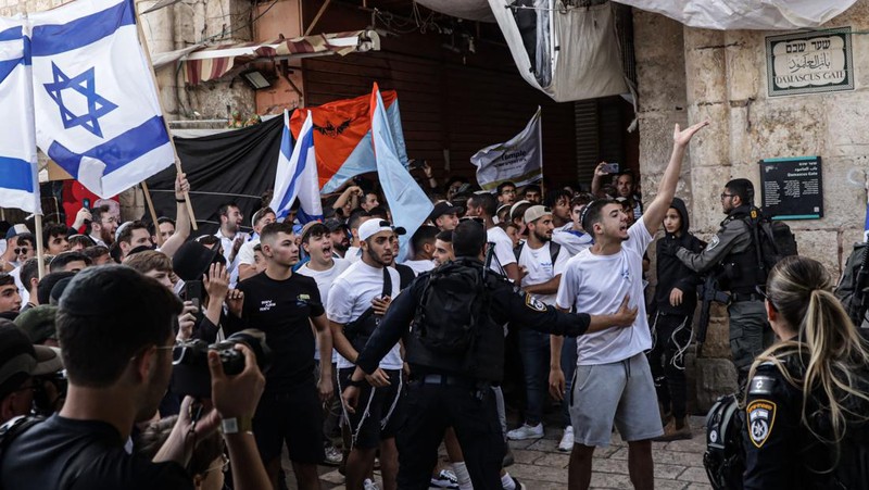 Yahudi Ultranasionalis Israel memegang bendera Israel saat mereka berbaris di kawasan Muslim kota tua Yerusalem pada 18 Mei 2023 di Yerusalem, Israel. Otoritas Israel akan mengizinkan orang-orang Yahudi Ortodoks berparade melalui Muslim Quarter Yerusalem dalam sebuah keputusan yang mengancam akan memicu kembali kekerasan di kota suci tersebut. (Amir Levy/Getty Images)