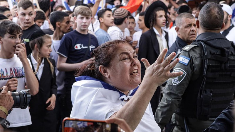 Yahudi Ultranasionalis Israel memegang bendera Israel saat mereka berbaris di kawasan Muslim kota tua Yerusalem pada 18 Mei 2023 di Yerusalem, Israel. Otoritas Israel akan mengizinkan orang-orang Yahudi Ortodoks berparade melalui Muslim Quarter Yerusalem dalam sebuah keputusan yang mengancam akan memicu kembali kekerasan di kota suci tersebut. (Amir Levy/Getty Images)