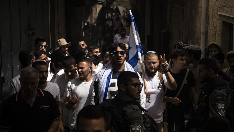 Yahudi Ultranasionalis Israel memegang bendera Israel saat mereka berbaris di kawasan Muslim kota tua Yerusalem pada 18 Mei 2023 di Yerusalem, Israel. Otoritas Israel akan mengizinkan orang-orang Yahudi Ortodoks berparade melalui Muslim Quarter Yerusalem dalam sebuah keputusan yang mengancam akan memicu kembali kekerasan di kota suci tersebut. (Amir Levy/Getty Images)