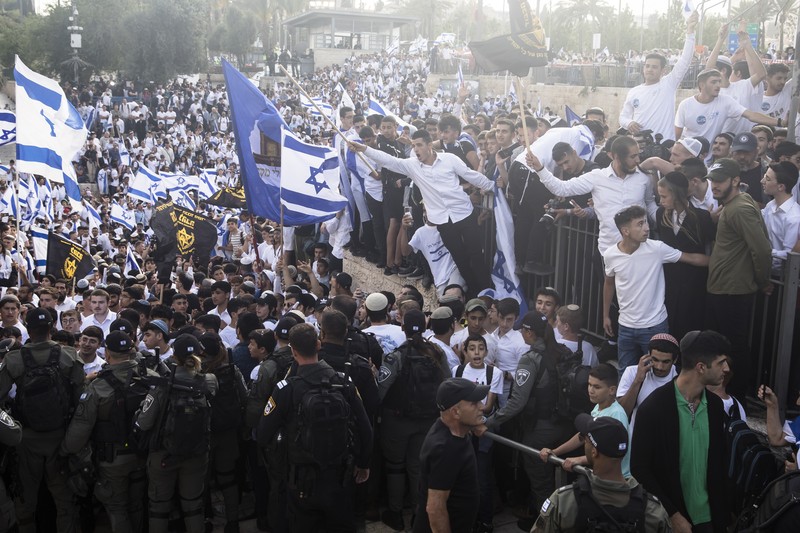 Yahudi Ultranasionalis Israel memegang bendera Israel saat mereka berbaris di kawasan Muslim kota tua Yerusalem pada 18 Mei 2023 di Yerusalem, Israel. Otoritas Israel akan mengizinkan orang-orang Yahudi Ortodoks berparade melalui Muslim Quarter Yerusalem dalam sebuah keputusan yang mengancam akan memicu kembali kekerasan di kota suci tersebut. (Amir Levy/Getty Images)