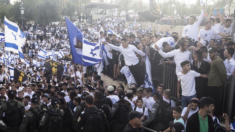 Yahudi Ultranasionalis Israel memegang bendera Israel saat mereka berbaris di kawasan Muslim kota tua Yerusalem pada 18 Mei 2023 di Yerusalem, Israel. Otoritas Israel akan mengizinkan orang-orang Yahudi Ortodoks berparade melalui Muslim Quarter Yerusalem dalam sebuah keputusan yang mengancam akan memicu kembali kekerasan di kota suci tersebut. (Amir Levy/Getty Images)