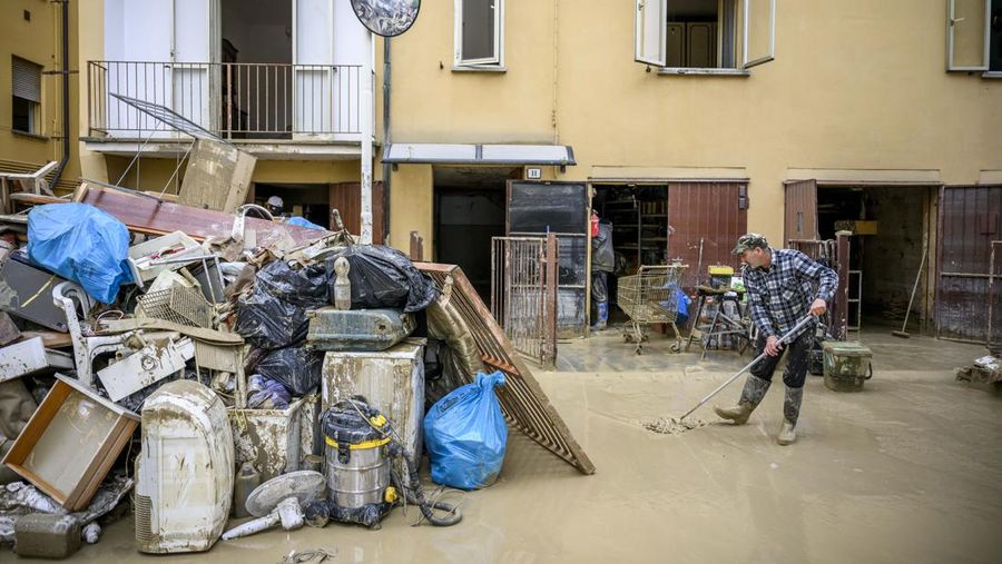 Warga membersihkan rumah mereka setelah hujan lebat menyebabkan banjir di wilayah Emilia Romagna utara Italia, pada 19 Mei 2023 di Faenza, Italia. Empat belas orang tewas dan ribuan orang telah dievakuasi dari rumah mereka setelah hujan deras menimbulkan kekacauan di wilayah Italia utara Emilia-Romagna, menyebabkan banjir dan tanah longsor yang parah. (Antonio Masiello/Getty Images)