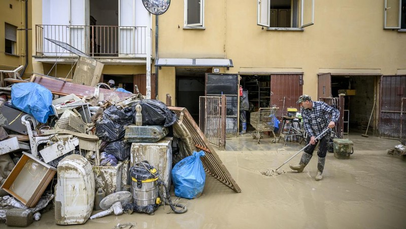 Warga membersihkan rumah mereka setelah hujan lebat menyebabkan banjir di wilayah Emilia Romagna utara Italia, pada 19 Mei 2023 di Faenza, Italia. Empat belas orang tewas dan ribuan orang telah dievakuasi dari rumah mereka setelah hujan deras menimbulkan kekacauan di wilayah Italia utara Emilia-Romagna, menyebabkan banjir dan tanah longsor yang parah. (Antonio Masiello/Getty Images)