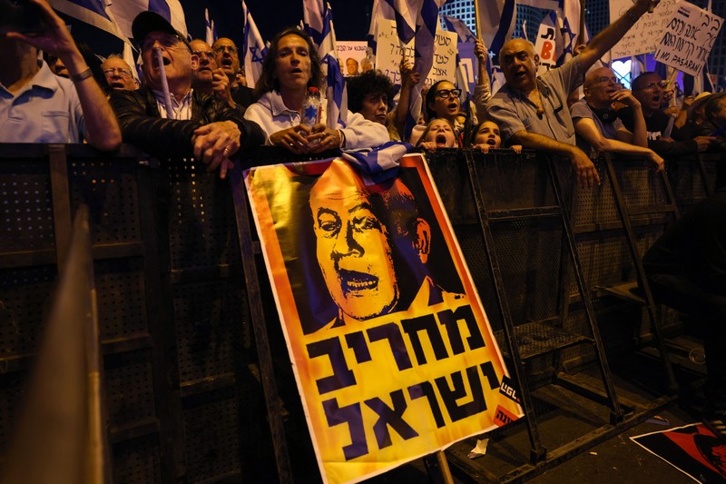 Demonstran mengibarkan bendera selama protes terhadap RUU perbaikan peradilan pemerintah Israel di Tel Aviv pada 20 Mei 2023. (AHMAD GHARABLI/AFP via Getty Images)