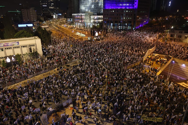 Demonstran mengibarkan bendera selama protes terhadap RUU perbaikan peradilan pemerintah Israel di Tel Aviv pada 20 Mei 2023. (AHMAD GHARABLI/AFP via Getty Images)