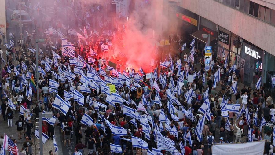 Demonstran mengibarkan bendera selama protes terhadap RUU perbaikan peradilan pemerintah Israel di Tel Aviv pada 20 Mei 2023. (AHMAD GHARABLI/AFP via Getty Images)