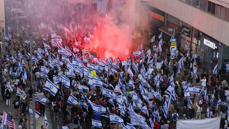 Demonstran mengibarkan bendera selama protes terhadap RUU perbaikan peradilan pemerintah Israel di Tel Aviv pada 20 Mei 2023. (AHMAD GHARABLI/AFP via Getty Images)