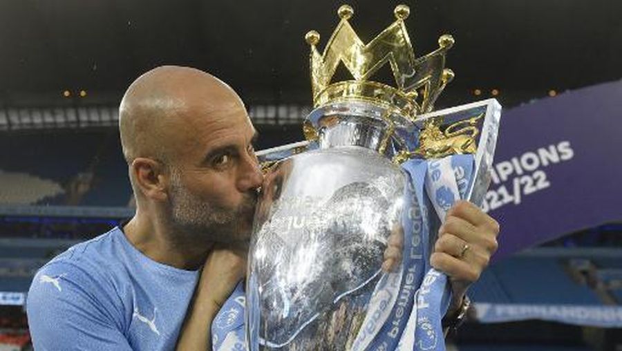 (FILES) Manchester City's Spanish manager Pep Guardiola celebrates with the Premier league trophy on the pitch after the English Premier League football match between Manchester City and Aston Villa at the Etihad Stadium in Manchester, north west England, on May 22, 2022. Manchester City's domestic dominance under Pep Guardiola has made a mockery of the Premier League's claim to be more competitive than Europe's other top leagues. City sealed a fifth title in six seasons on May 20, 2023, with three games to spare, having ultimately seen off Arsenal's challenge to win the league for the first time in 19 years with ease. (Photo by Oli SCARFF / AFP) / RESTRICTED TO EDITORIAL USE. No use with unauthorized audio, video, data, fixture lists, club/league logos or 'live' services. Online in-match use limited to 120 images. An additional 40 images may be used in extra time. No video emulation. Social media in-match use limited to 120 images. An additional 40 images may be used in extra time. No use in betting publications, games or single club/league/player publications. /