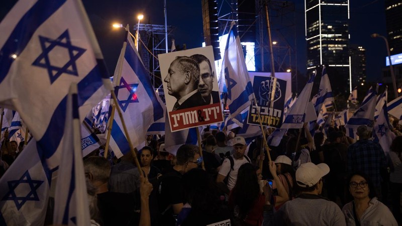 Demonstran mengibarkan bendera selama protes terhadap RUU perbaikan peradilan pemerintah Israel di Tel Aviv pada 20 Mei 2023. (AHMAD GHARABLI/AFP via Getty Images)