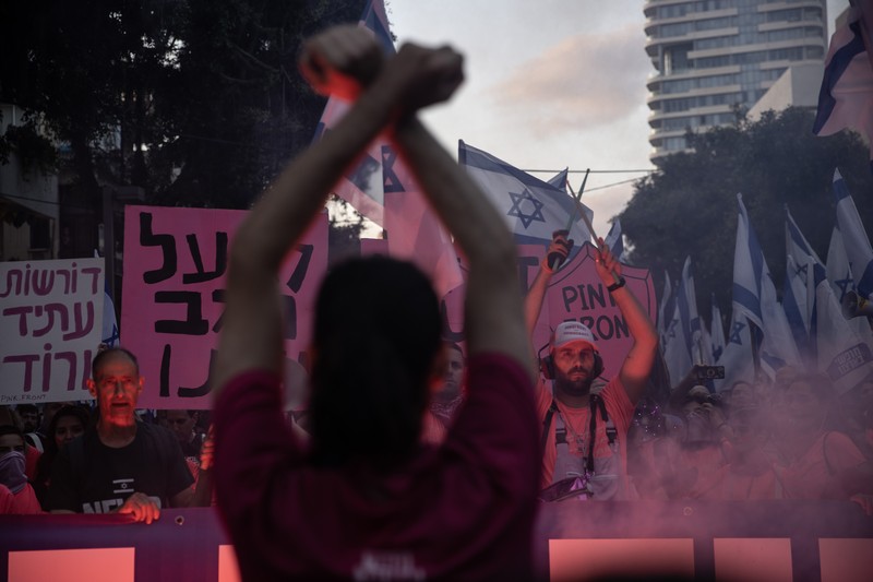 Demonstran mengibarkan bendera selama protes terhadap RUU perbaikan peradilan pemerintah Israel di Tel Aviv pada 20 Mei 2023. Demonstran mengibarkan bendera selama protes terhadap RUU perbaikan peradilan pemerintah Israel di Tel Aviv pada 20 Mei 2023. (AHMAD GHARABLI/AFP via Getty Images)